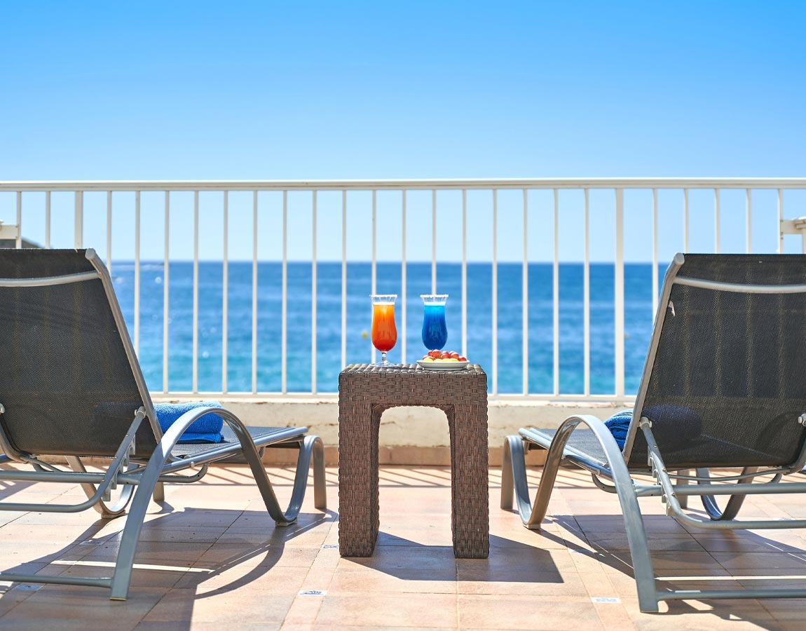 Terraza con mesa y cocktails Detalle de la terraza con hamacas con mesa y dos cockteles